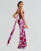 Woman wearing a pink floral dress with a long train on a white background