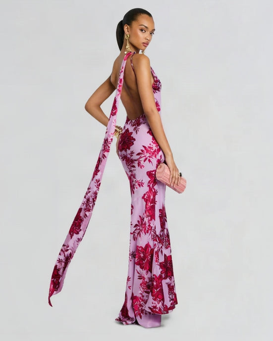 Woman wearing a pink floral dress with a long train on a white background